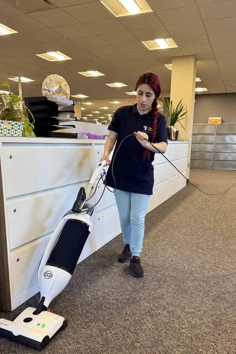Commercial cleaner vacuuming office space